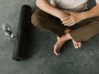 Roll of yoga mat and water bottle on floor